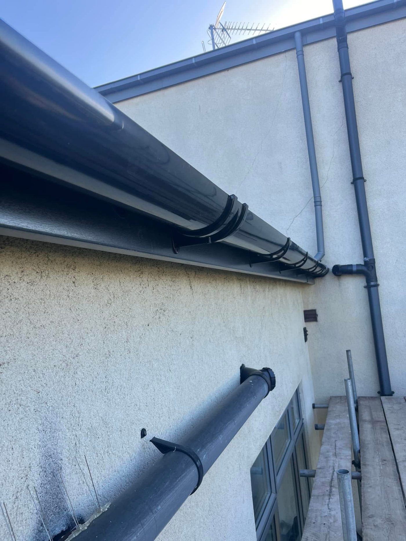 New dark grey fascia board and black gutters fitted along a roofline